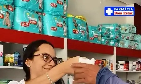 Atendente entregando um pedido no balcão da Farmácia Bem Estar