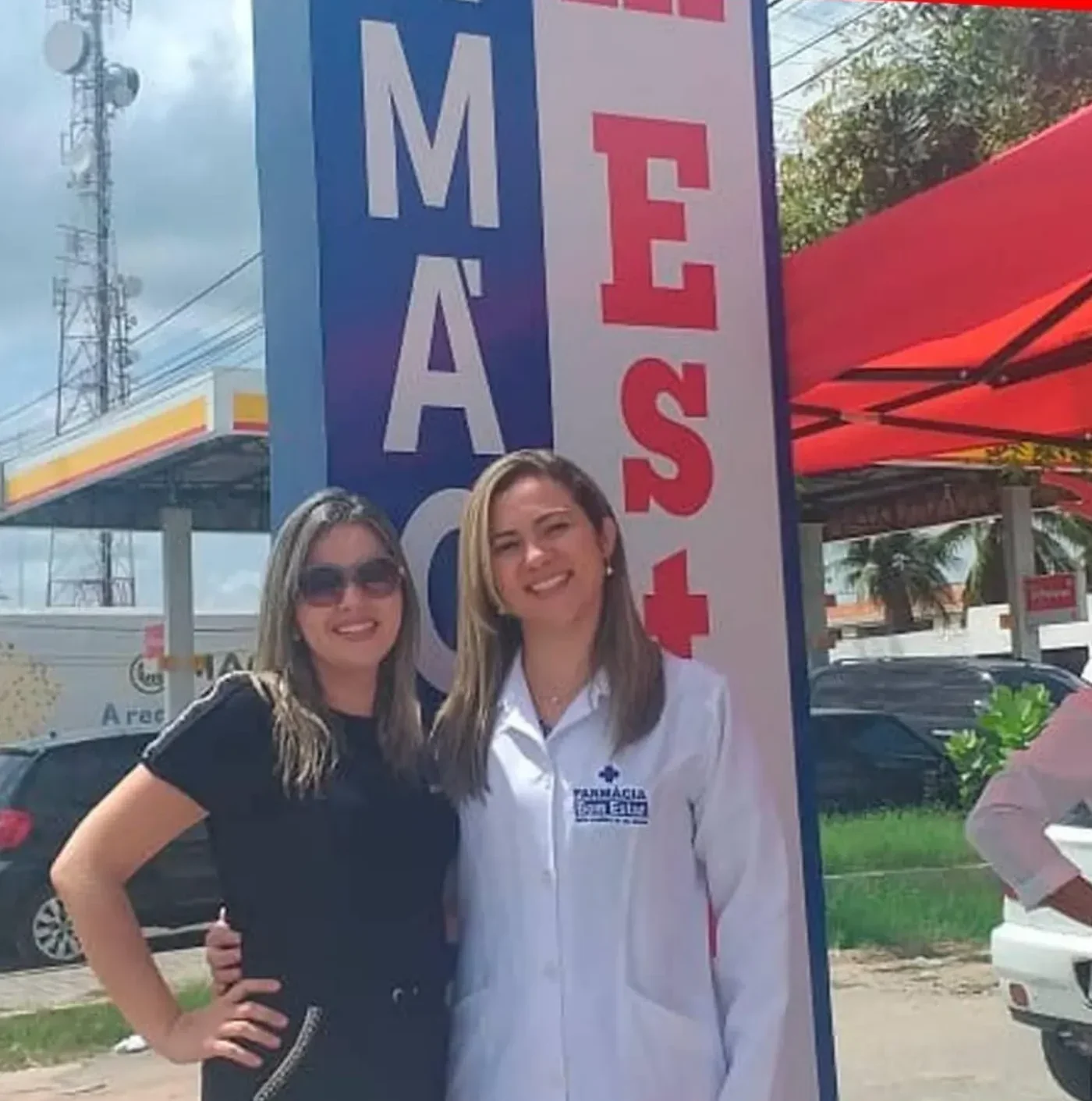 Farmacêutica em frente à fachada da Farmácia Bem Estar